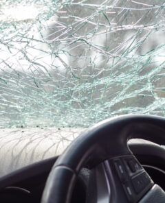 Damaged car window after an accident. Broken windshield as a result of an accident, inside view. Cabin interior details, view from the cab. Safe movement. Broken windshield. Glass crack and damage